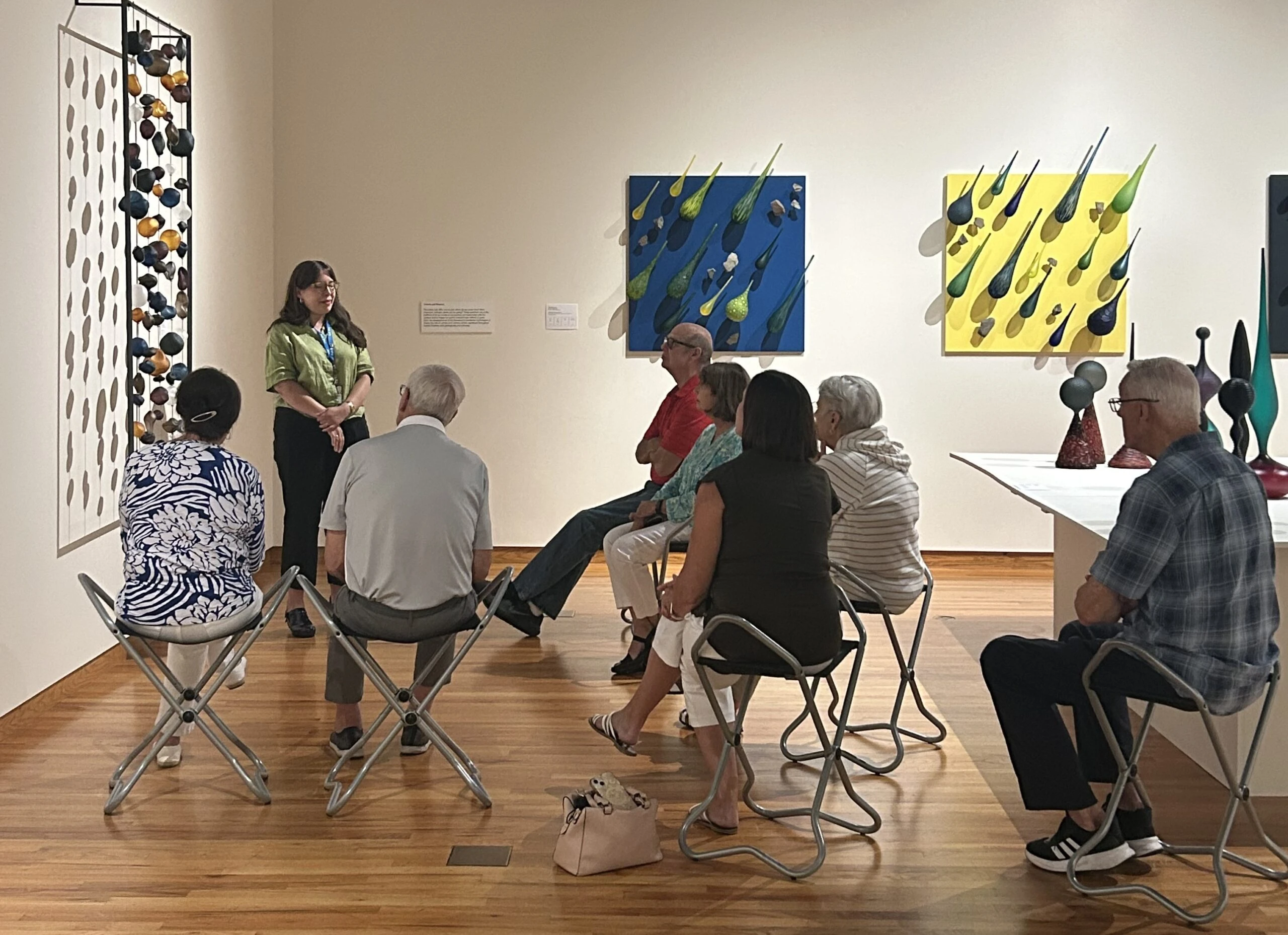8.19.2 Older adults seated in an art gallery with a tour guide speaking to them