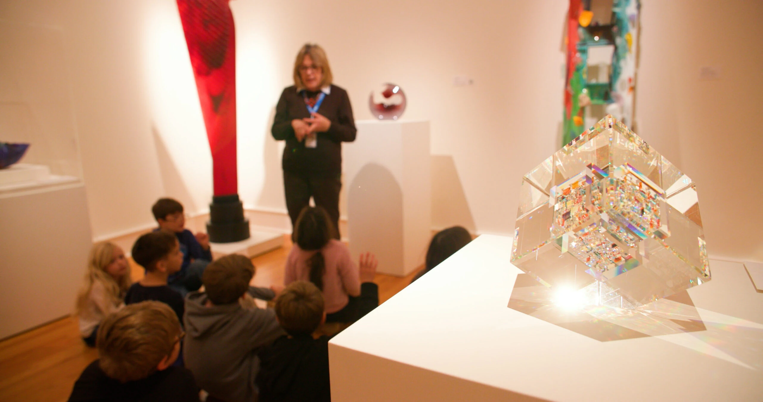 Still_010 children sitting in an art gallery with a tour guide speaking to them