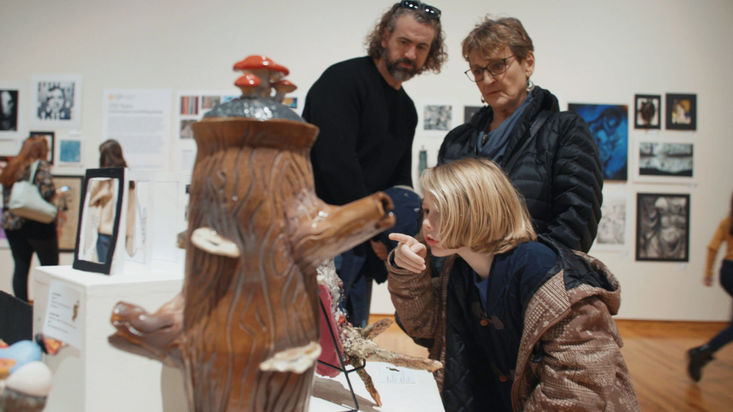 still photos.00_00_38_11.Still009 child looking at artwork in gallery with two adults